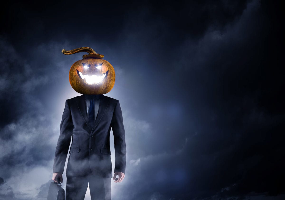 Scary businessman with jack-o-lantern head