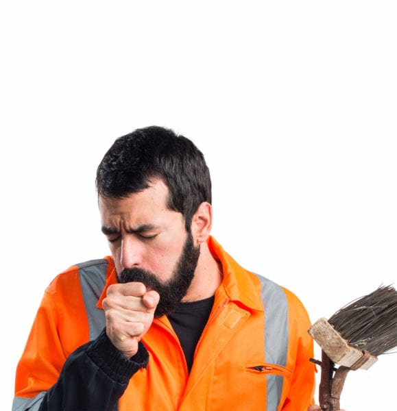 Construction worker coughs into his hand