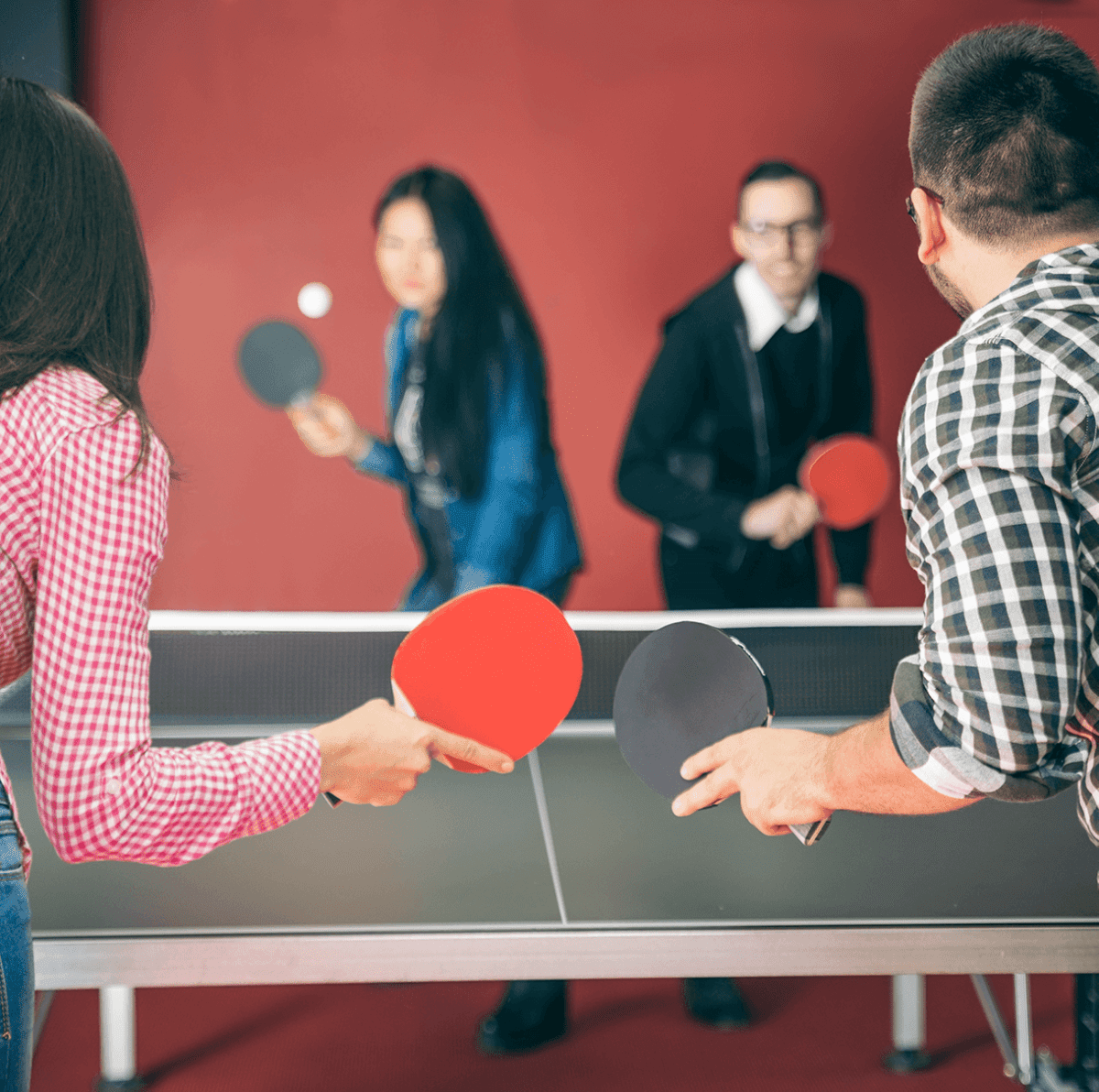 Four people play ping-pong