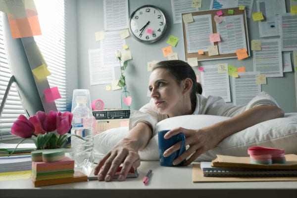 Woman works on a computer from her bed